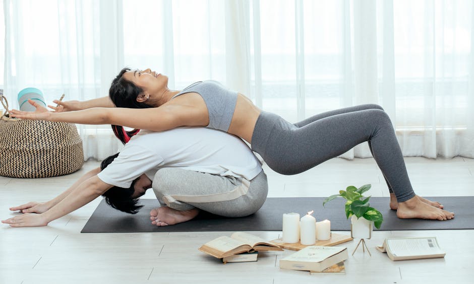 Couple in a harmonious partner yoga pose on a yoga mat in a light-filled room.